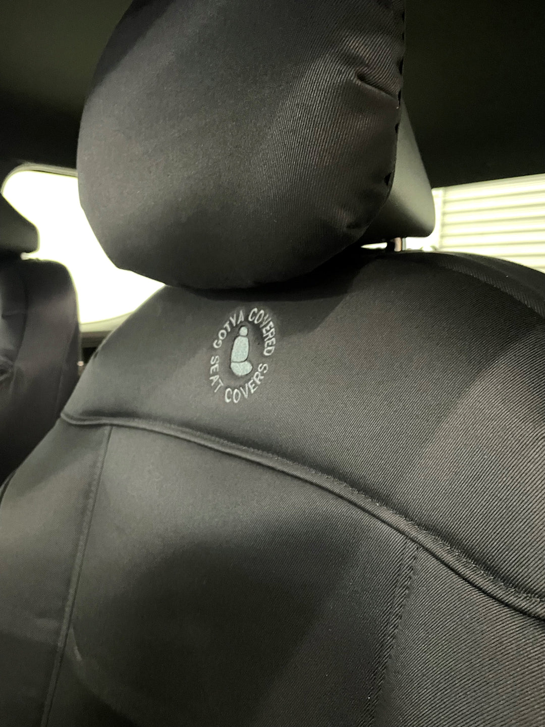 close up of kia tasman passenger seat fitted with denim seat cover and GYC logo.