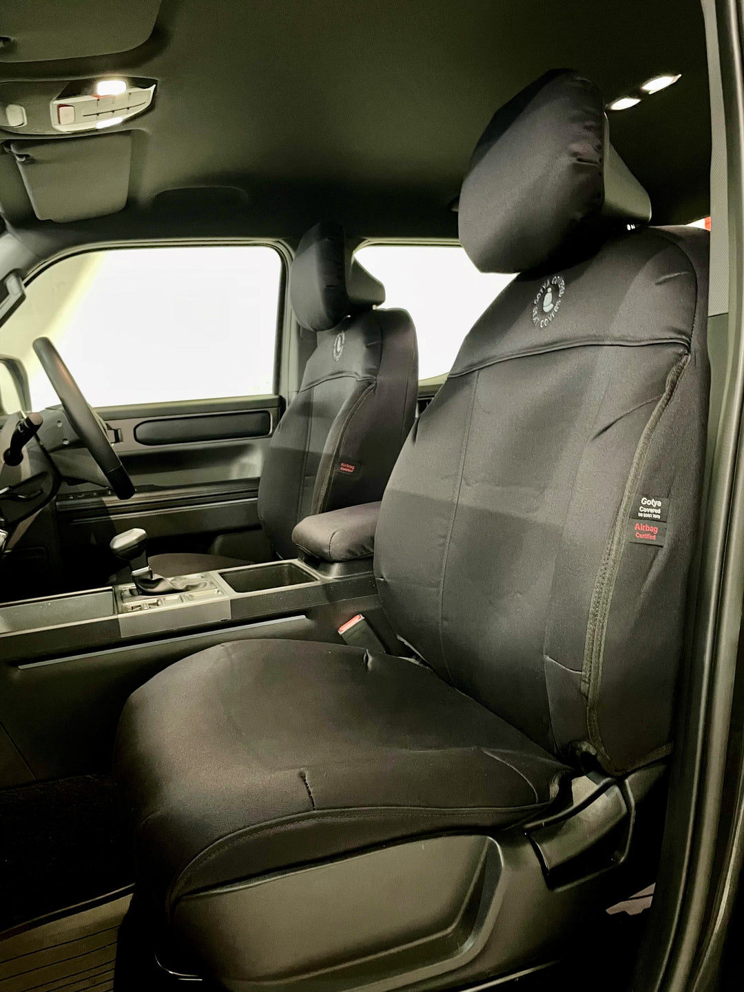 Kia tasman interior showingblack denim seat covers on front seats.
