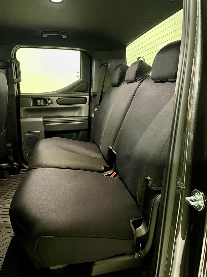 rear seat of kia tasman fitted with black denim seat covers.